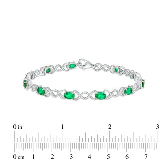 Oval Lab-Created Emerald and 0.18 CT. T.W. Diamond Infinity Ribbon Link Line Bracelet in Sterling Silver – 7.5"|Peoples Jewellers