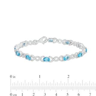 Oval Blue Topaz and 0.18 CT. T.W. Diamond Infinity Ribbon Link Line Bracelet in Sterling Silver – 7.5"|Peoples Jewellers