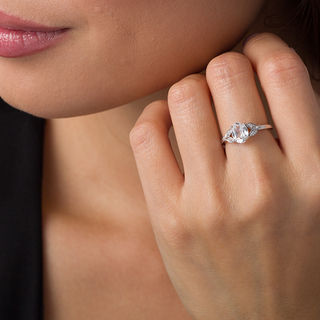 Oval Lab-Created White Sapphire and 0.086 CT. T.W. Diamond Leaf Sides Ring in Sterling Silver