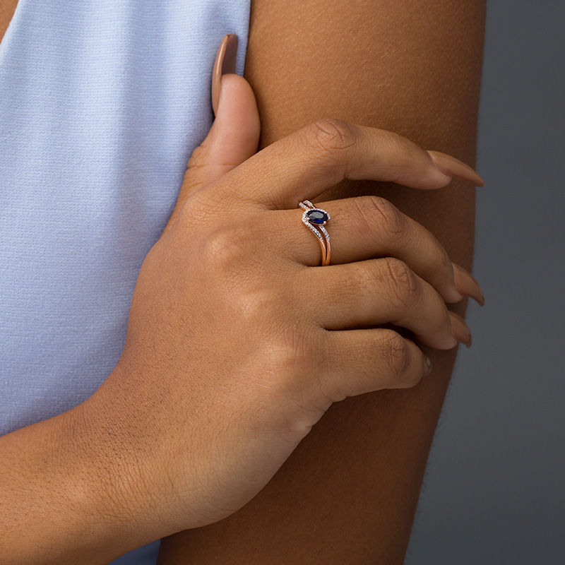 Oval Lab-Created Blue Sapphire and 0.065 CT. T.W. Diamond Swirling Bypass Split Shank Promise Ring in 10K Rose Gold