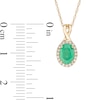 Oval Emerald and 0.08 CT. T.W. Diamond Frame Twist Drop Pendant in 10K Gold