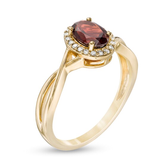 Oval Garnet and 0.08 CT. T.W. Diamond Frame Twist Shank Ring in 10K Gold