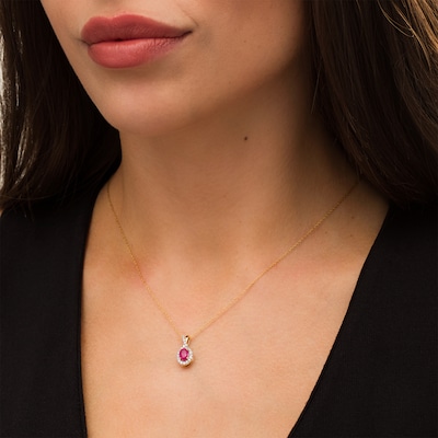 Oval Ruby and 0.15 CT. T.W. Diamond Frame Twist Drop Pendant in 10K Gold