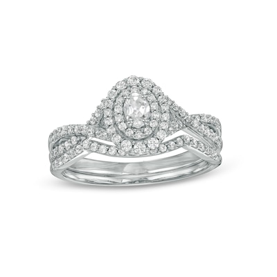 0.58 CT. T.W. Oval Diamond Double Frame Twist Shank Bridal Set in 10K White Gold (I/I2)