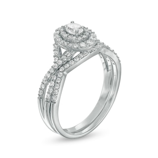 0.58 CT. T.W. Oval Diamond Double Frame Twist Shank Bridal Set in 10K White Gold (I/I2)