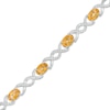 Thumbnail Image 0 of Oval Citrine and 0.18 CT. T.W. Diamond Infinity Ribbon Link Line Bracelet in Sterling Silver – 7.5"