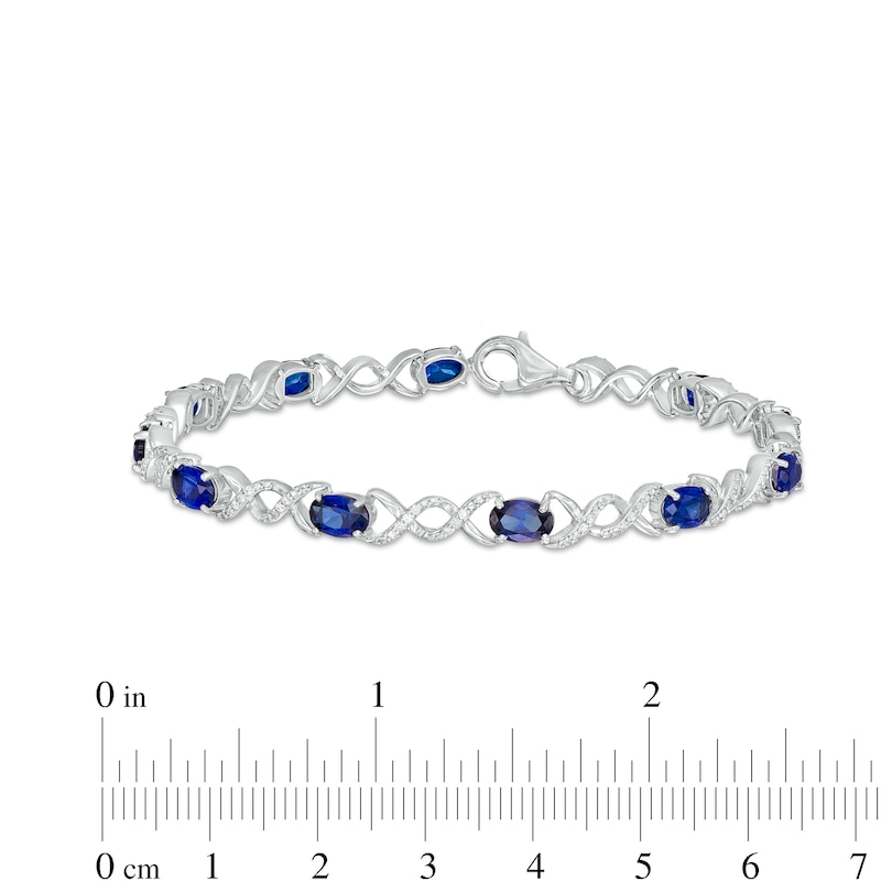 Oval Blue Lab-Created Sapphire and 0.18 CT. T.W. Diamond Infinity Ribbon Link Line Bracelet in Sterling Silver – 7.5"