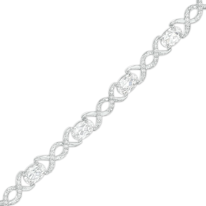 Oval White Lab-Created Sapphire and 0.18 CT. T.W. Diamond Infinity Ribbon Link Line Bracelet in Sterling Silver – 7.5"