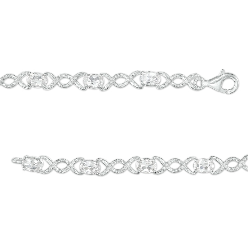 Oval White Lab-Created Sapphire and 0.18 CT. T.W. Diamond Infinity Ribbon Link Line Bracelet in Sterling Silver – 7.5"