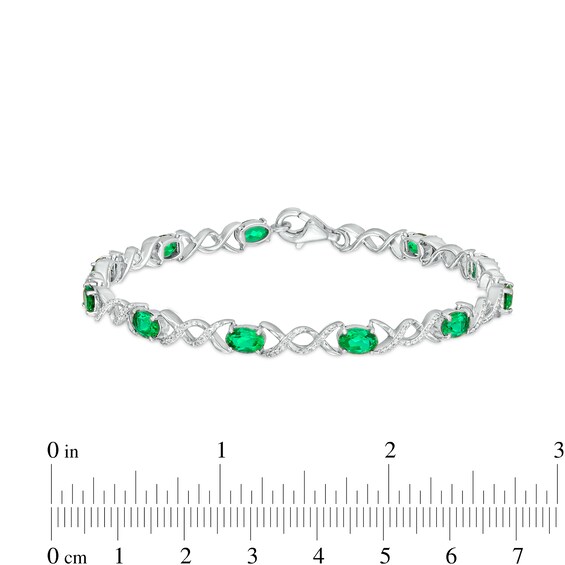 Oval Lab-Created Emerald and 0.18 CT. T.W. Diamond Infinity Ribbon Link Line Bracelet in Sterling Silver – 7.5"