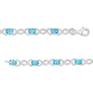 Oval Blue Topaz and 0.18 CT. T.W. Diamond Infinity Ribbon Link Line Bracelet in Sterling Silver – 7.5"