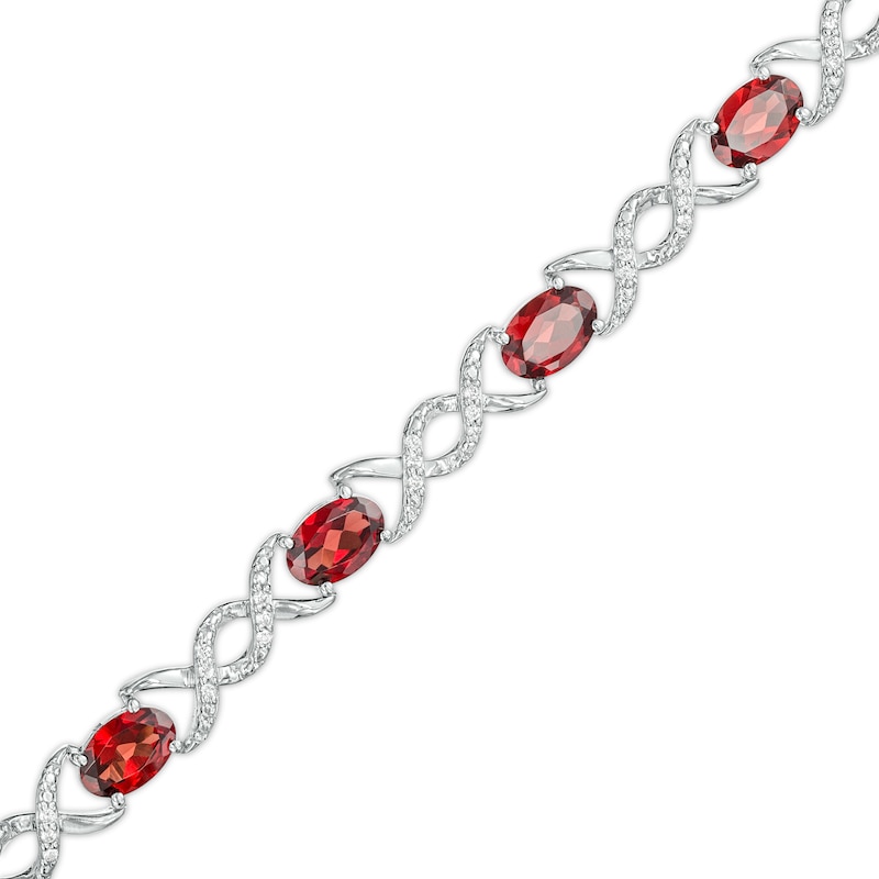 Oval Garnet and 0.18 CT. T.W. Diamond Infinity Ribbon Link Line Bracelet in Sterling Silver – 7.5"