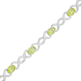 Oval Peridot and 0.18 CT. T.W. Diamond Infinity Ribbon Link Line Bracelet in Sterling Silver – 7.5&quot;