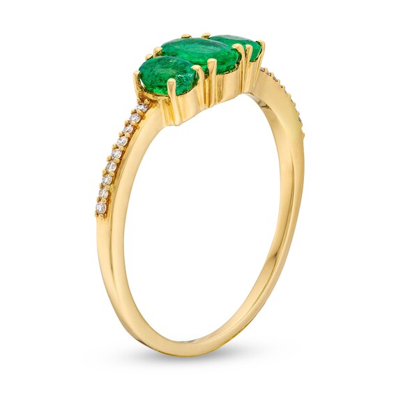 Oval Emerald and 0.05 CT. T.W. Diamond Three Stone Ring in 10K Gold