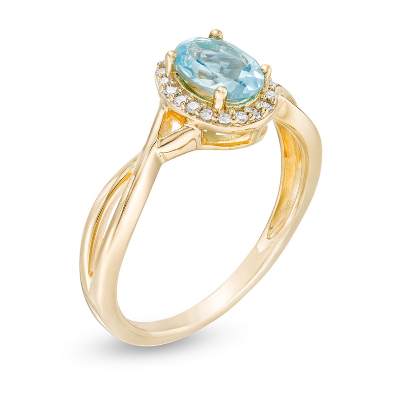 Previously Owned - Oval Swiss Blue Topaz and 0.08 CT. T.W. Diamond Frame Twist Shank Ring in 10K Gold