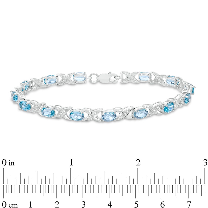 Previously Owned - Sideways Oval Swiss Blue Topaz and Diamond Accent "XO" Bracelet in Sterling Silver - 7.25"