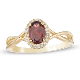 Previously Owned - Oval Garnet and 0.08 CT. T.W. Diamond Frame Twist Shank Ring in 10K Gold